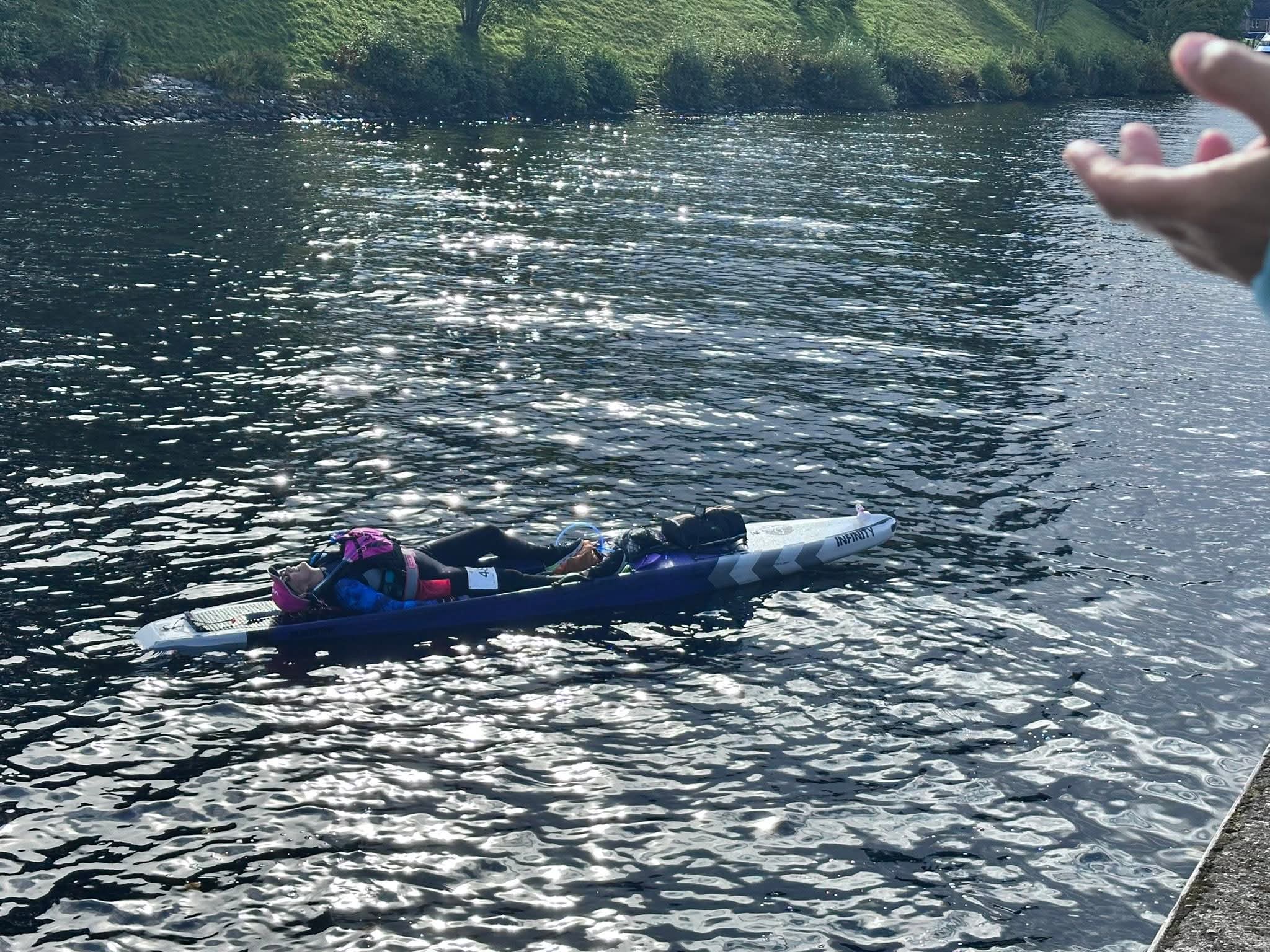 Kim across the line, lying on the paddleboard